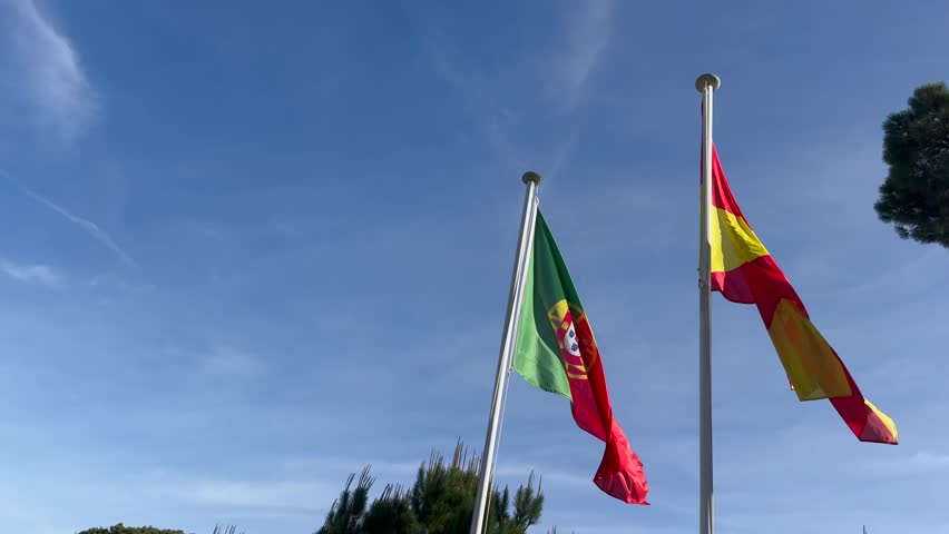 Wavy Spain and Potugal Flags and Clear Blue Sky