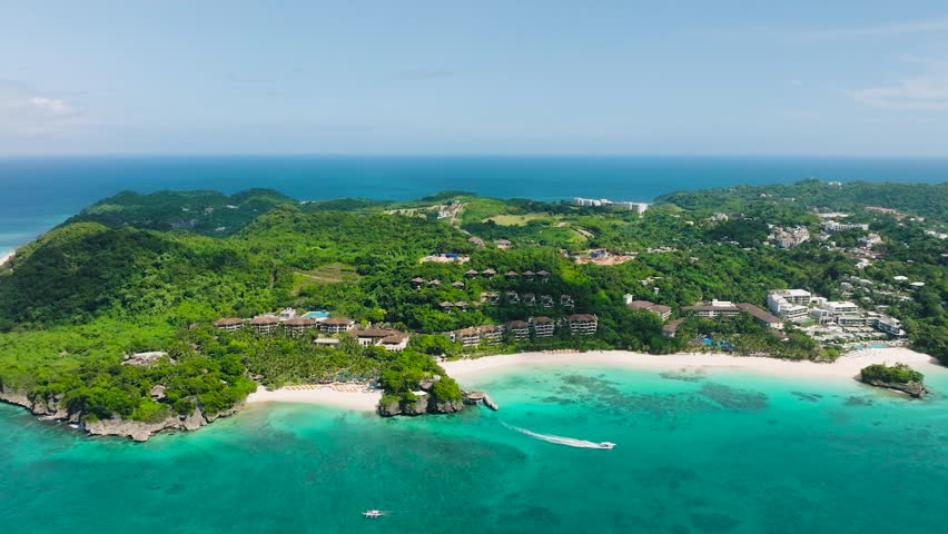 Beach resorts with white sands and tourist boat running over transparent sea water. Boracay Island. Philippines.