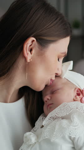 Mother lovingly embraces and kisses her infant child, celebrating precious moments of family connection and new life