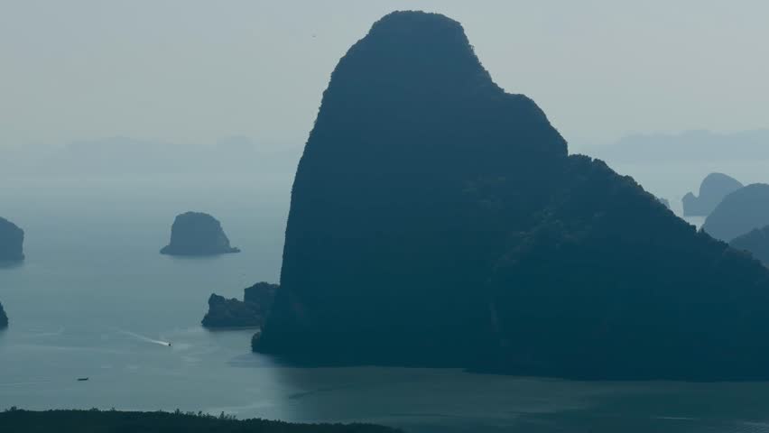 Spectacular limestone karst formations and islands rising from Phang Nga Bay at Samet Nangshe viewpoint, Thailand. Majestic tropical mountain landscape and sea under misty sky. Natural rock wonders.