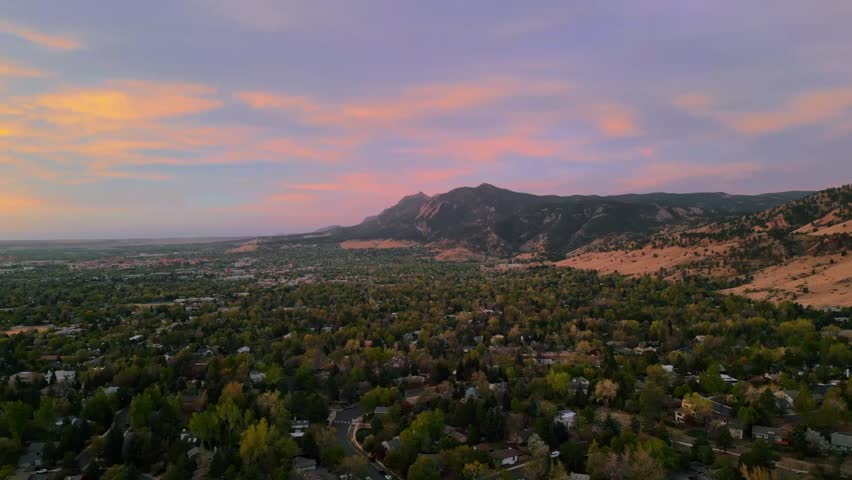 Sunrise with colorful clouds over the flatiron mountains in boulder colorado