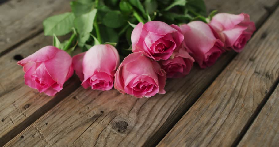 Bouquet of pink roses on wooden background at valentine