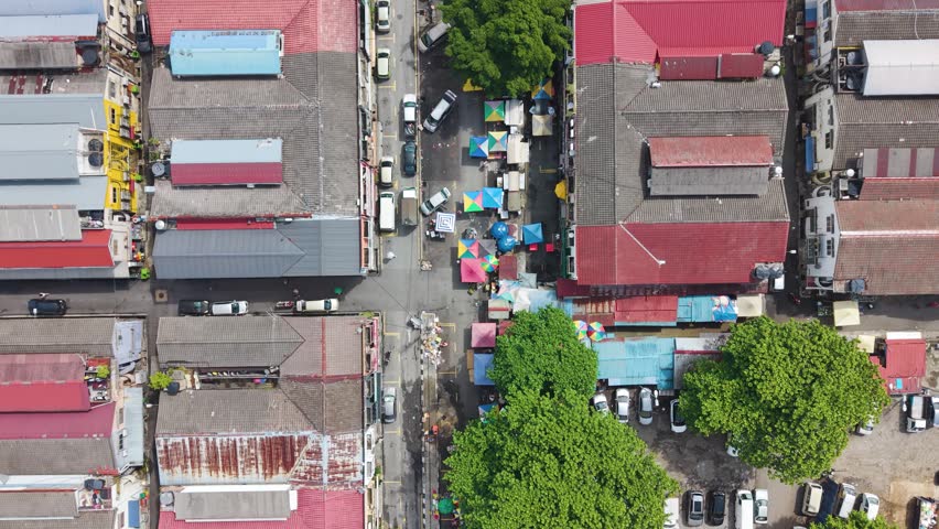 Top-down aerial view of Cheras district market street in Kuala Lumpur, Malaysia. Dense urban layout with colorful rooftops, street activity, and a local commercial area.