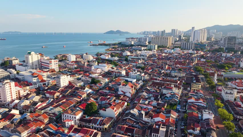 Push in drone shot of George Town, the old town in Penang, with dense heritage buildings and colorful rooftops, showcasing historic architecture and urban layout in Malaysia UHD.