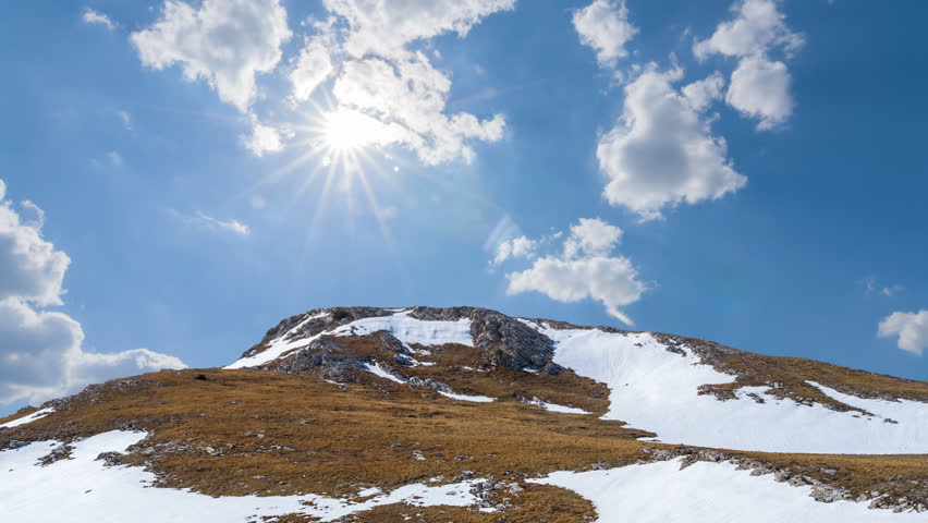mount top in a snow under a sparkle sun time lapse scene
