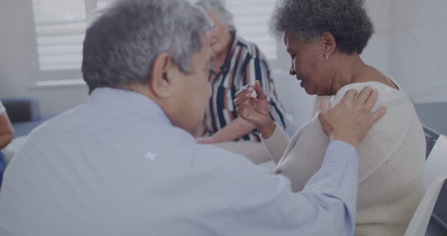 Vertical video: Man reaching, placing hand, woman wiping, circuit overlay appearing, calming scene. Eldercare, empathy, trio, lounge, digital, wellness, photoreal