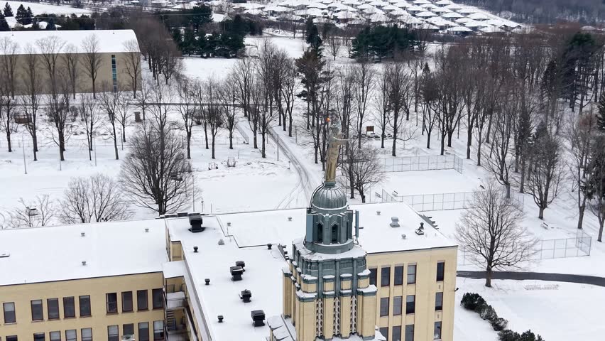 Aerial winter view of Mont Sacre Coeur middle school campus with snowy buildings and forest, Granby, Quebec, Canada. g.