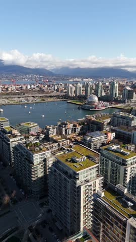 Vancouver Skyline Looking North Across False Creek Towards The North Shore Mountains In Canada - Drone, Vertical Shot