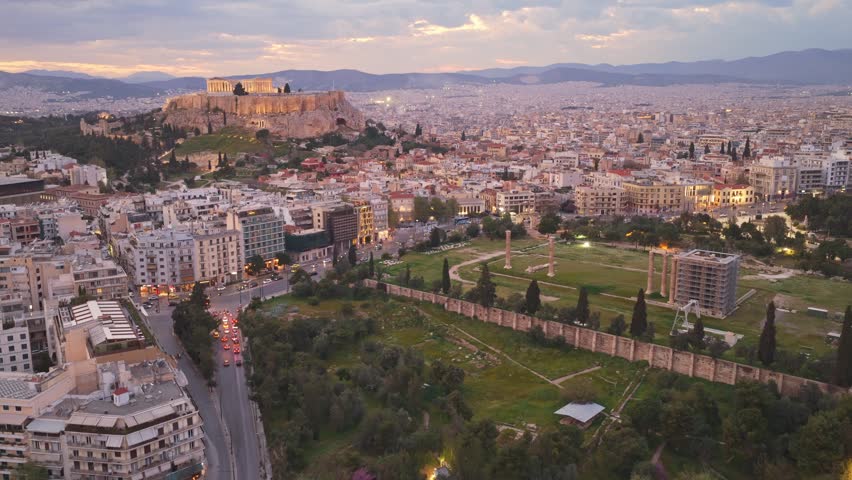 Aerial perspective of athens, greece, featuring the illuminated acropolis with the parthenon and the ancient ruins of the temple of olympian zeus against a beautiful twilight cityscape