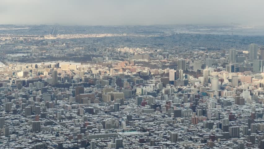 Aerial View of Sapporo Cityscape in Winter with Snow and Sunlight