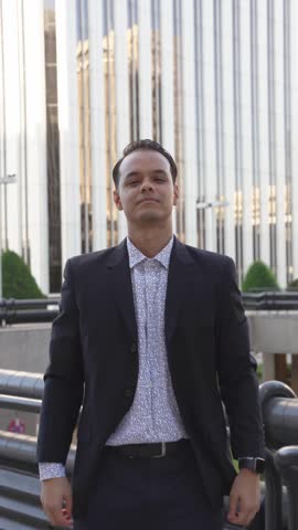 Young handsome businessman adjusting his suit jacket and shirt collar with confidence. Stylish professional male preparing for a meeting