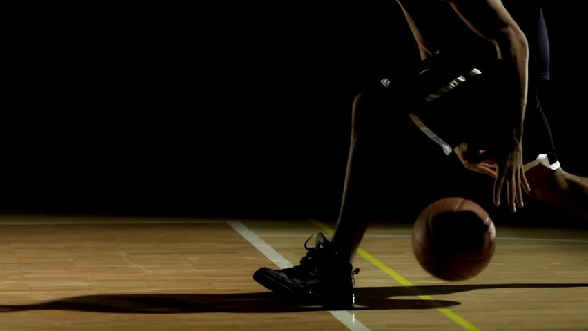 Close video of Basketball players legs during the game practice. Basketball player dribbling ball on indoor court. man training in dribbling basketball.