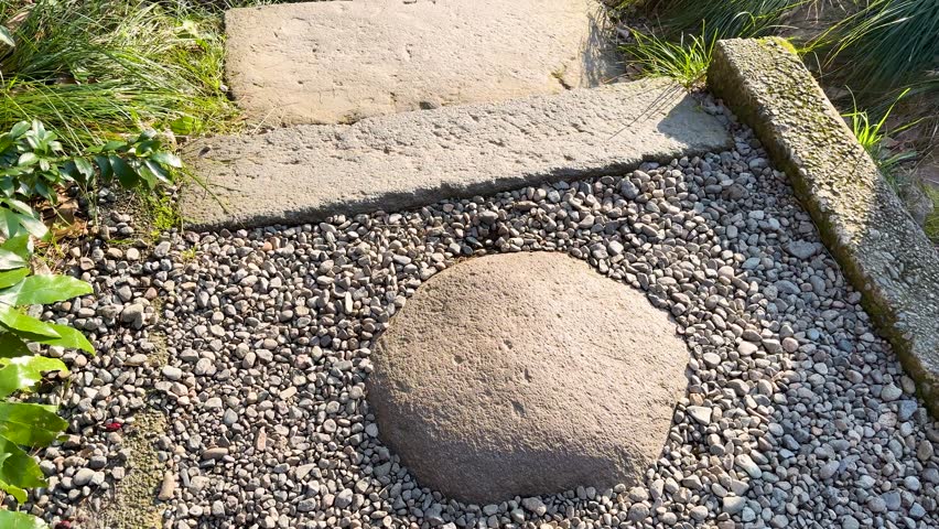 Stone steps leading to a tranquil stream with mossy rocks.