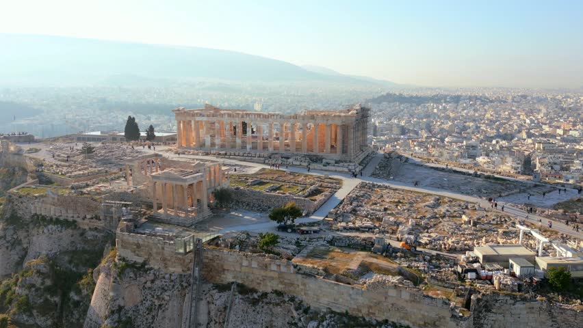 Aerial drone view of Parthenon on Acropolis in Athens, Greece. Detailed ancient ruins with cityscape in background, iconic historical landmark.