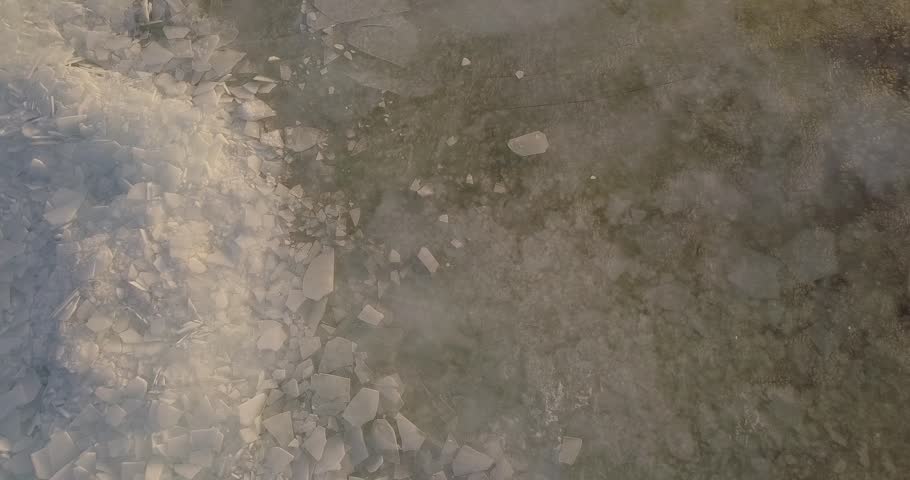 Flying over a frozen river, ice on the river in cold winter
