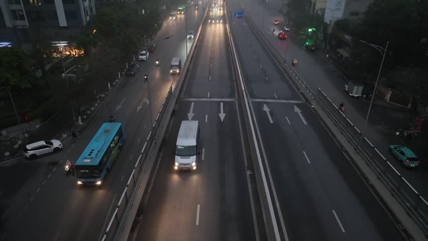 Aerial view of divided highway on Minh Khai street during foggy morning with buses, cars, and motorbikes moving through low visibility conditions.