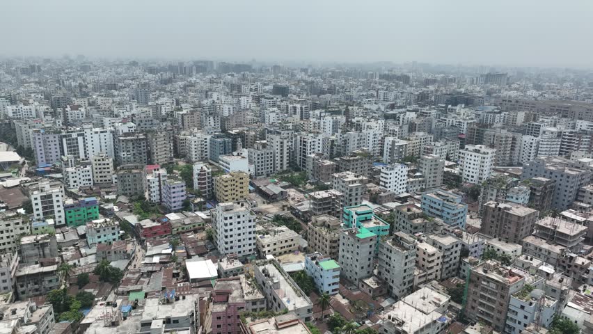 Aerial view flying slowly over the sprawling, densely packed residential and commercial buildings of dhaka, the capital city of bangladesh, showcasing massive urbanization and development
