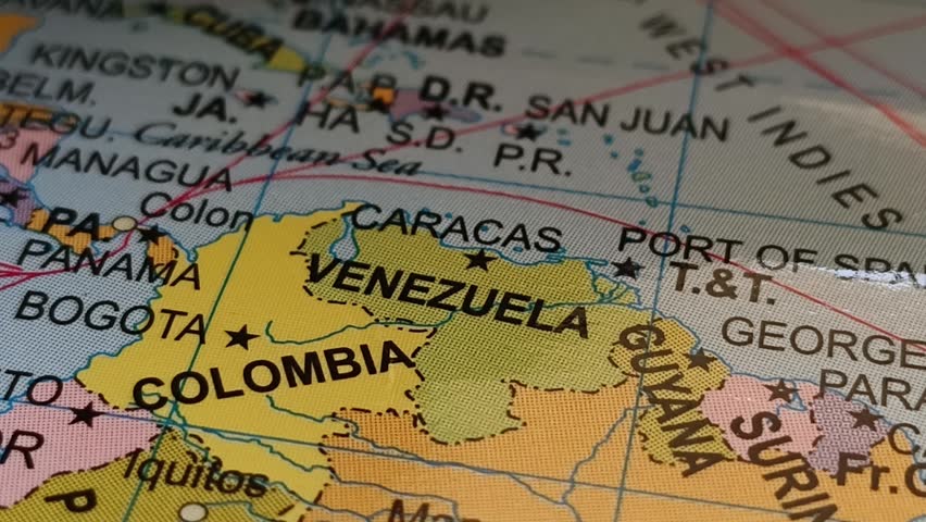 Closeup of pen tip touching venezuela county location or territory mark drawing on a map with Caracas capital city name word or text written. Travel tourism creative concept.