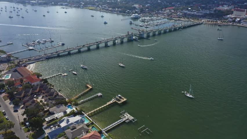Various boats travel under a bridge connecting St. Augustine
