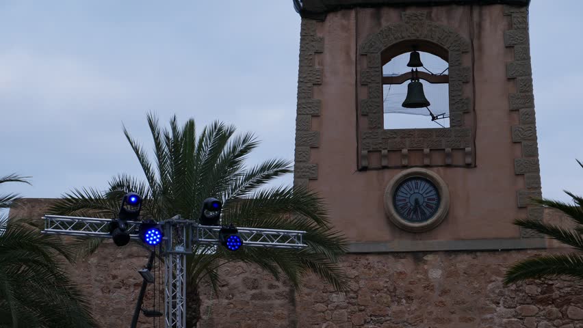 Stage lights mounted next to the clock of Santa Pola Castle, Spain