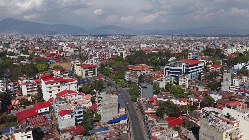 Aerial footage showing Kathmandu’s urban structure, buildings, and road networks surrounded by hills.
