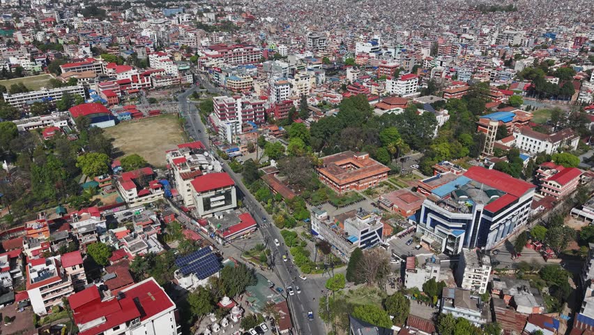 Aerial footage showing Kathmandu’s urban structure, buildings, and road networks surrounded by hills.