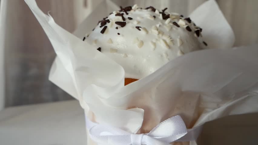 Easter vanilla cupcake with marshmallow frosting and chocolate sprinkles, close-up macro of homemade festive bakery dessert in paper wrapper, sweet confectionery treat.
