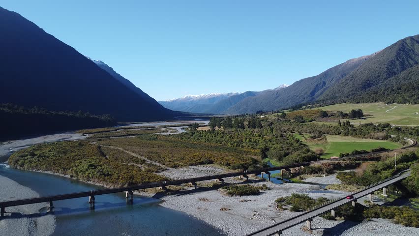 Wide aerial view of bridge and valley landscape with river in New Zealand.