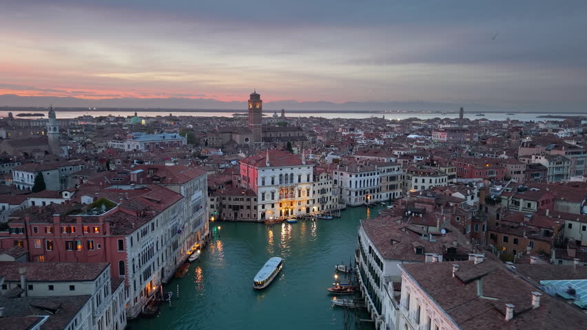 Venice evening sights. Sunset over Venice waterways. Twilight scene with gondolas and historic bridges. Italy