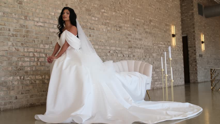 Beautiful bride wearing white wedding dress posing indoors
