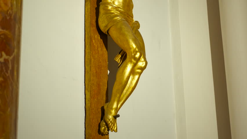 Golden jesus christ crucifix sculpture in church. Majestic gilded sculpture of jesus christ crucified on a wooden cross with a crown of thorns, a sacred symbol of christian faith