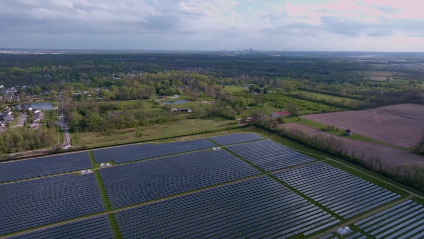 Aerial view of a large solar farm surrounded by green fields and trees in Indianapolis, Indiana, United States.