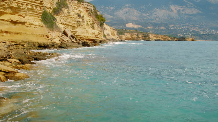 Mountain view over rocky Kefalonia shoreline and turquoise sea during summer