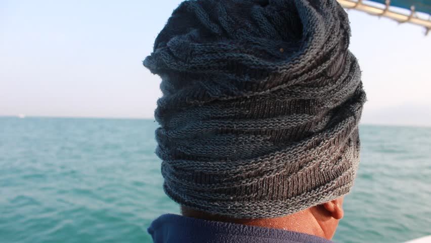 A small, open motorized boat is being used, featuring a blue and white bimini top for sun protection.
