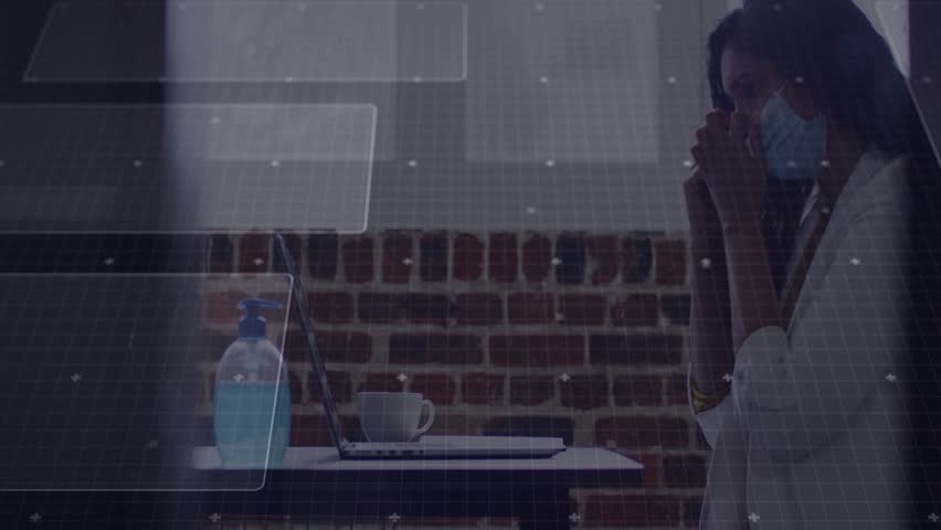 Woman holding smartphone, typing on laptop while handling tech call, managing work with HUD charts. Professional, female, mask, sanitizer, phone, computer, augmented