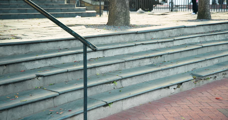 After burgundy-sweater climbing steps, beige coat woman descending steps toward walkway with bag. Staircase, promenade, outdoor, urban, pedestrians, backpack, handbag