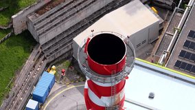 Aerial view of a red and white striped industrial chimney with solar panels and factory buildings in Bussi sul Tirino, Abruzzo, Italy. - Powered by Shutterstock - Get 15% off with code: PIKWIZARD15