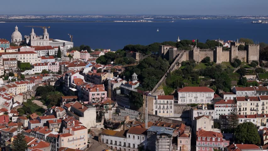 Aerial view of the historic Castelo de Sao Jorge overlooking red-roofed buildings and the Tagus River in Lisbon, Lisbon, Portugal.
