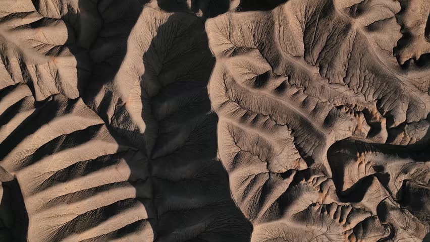 Aerial view of the intricate eroded ridges and deep shadows of Factory Butte in Wayne County, Utah, United States.