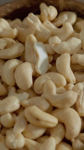 Vertical Screen: Cashew pieces are displayed in a rustic bowl, showcasing their natural form. Perfect for healthy snacking, baking, or cooking delicious meals.