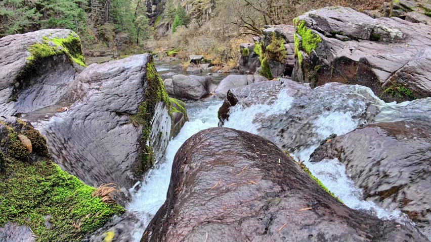 Fast Flowing Mountain Waterfall: Rushing White Water Cascading over Mossy Boulders