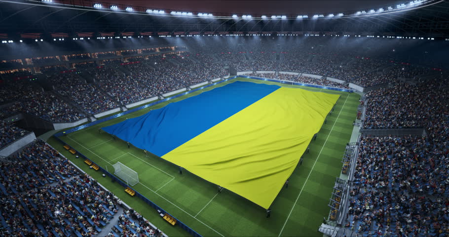 Professional Stadium With Soccer Game Championship With Flag of Ukraine Spread Across Pitch Before Football Match Start. Cheering Crowds of Fans at Arena During Ceremony. Aerial Static Wide Shot