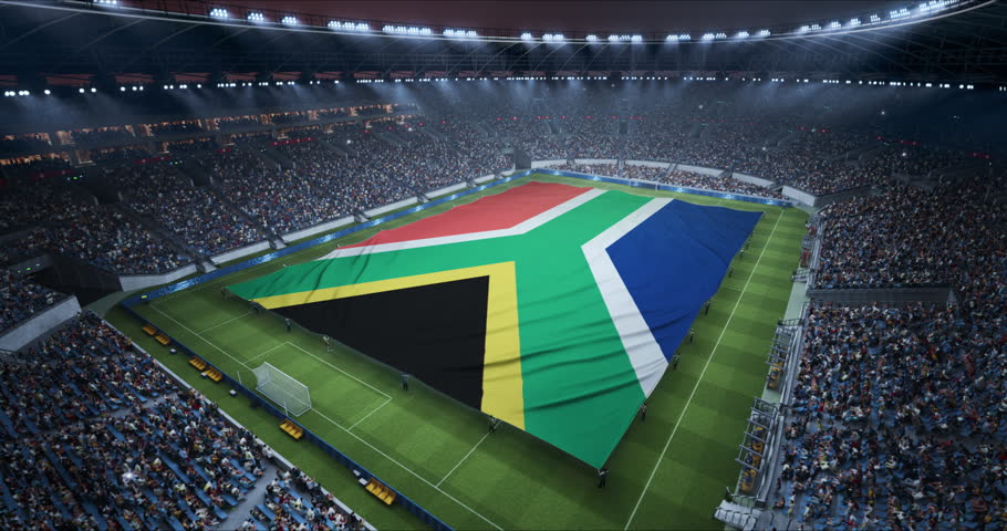 Professional Stadium With Soccer Game Championship With Flag of South Africa Spread Across Pitch Before Football Match Start. Cheering Crowds of Fans Ring the Arena in a Stirring Scene. Wide Shot