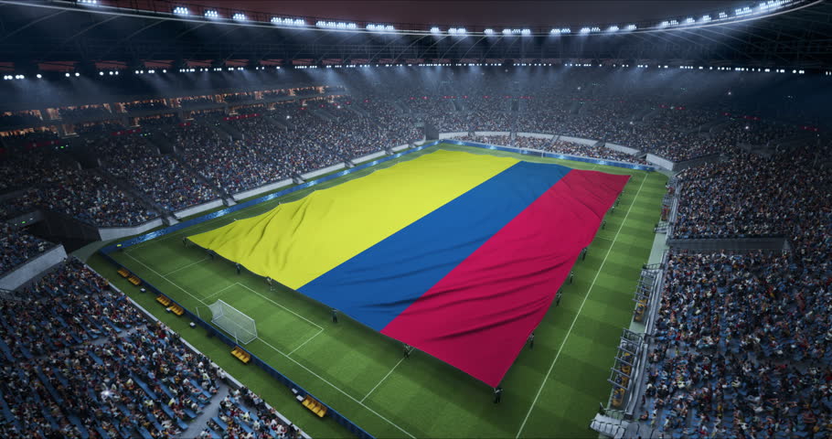 Professional Stadium With Soccer Game Championship With Flag of Colombia Spread Across Pitch Before Football Match Start. Cheering Crowds of Fans at Arena Anthem Ceremony. Aerial Static Wide Shot