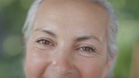 Senior woman slowly smiling while nodes popping and aligning over face, driving health tech mapping. Elderly, portrait, closeup, outdoors, greenery, bokeh, grid - Powered by Shutterstock - Get 15% off with code: PIKWIZARD15