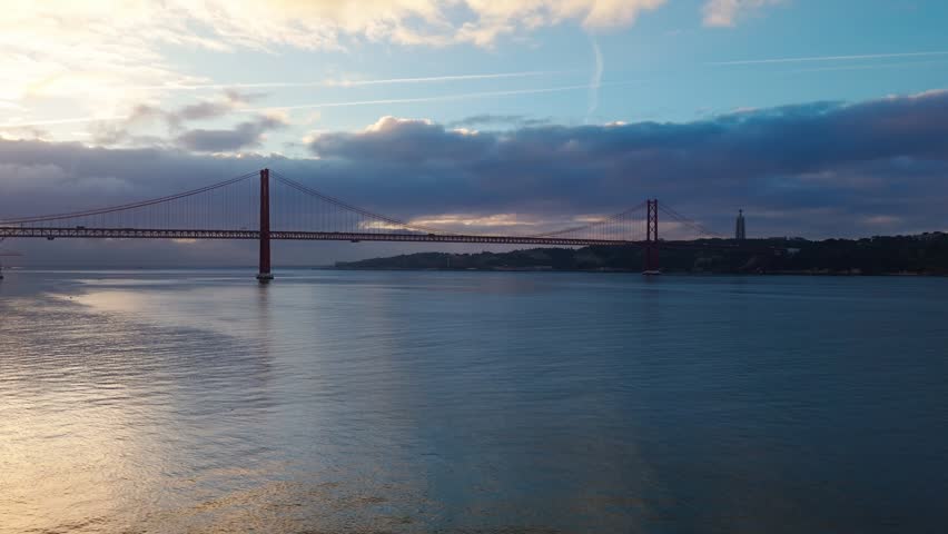 Aerial view of 25 de Abril Bridge over Tagus river in Lisbon, Portugal under dramatic clouds