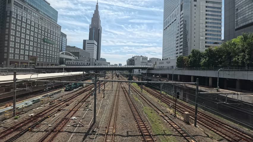 Railway tracks and trains near Shinjuku Station with skyscrapers and Docomo Tower in Tokyo,
