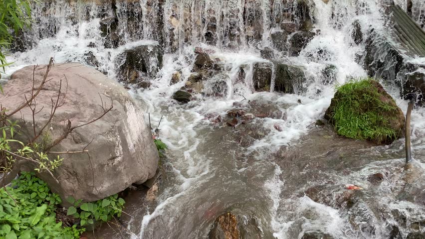 Fast water flowing downhill from waterbody in mountains 