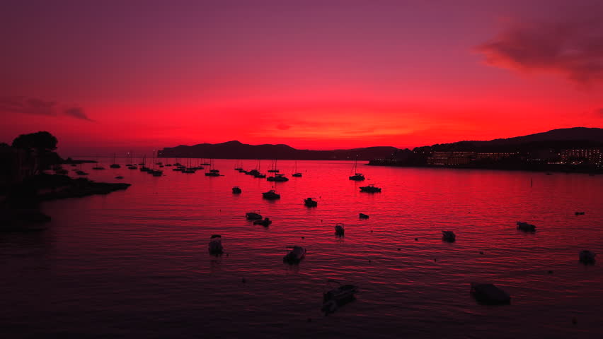 Peaceful mallorca bay glowing with sunset, anchored boats rocking softly
