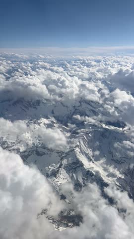Aerial view of clouds over snowy mountains